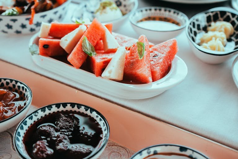 A close-up of a vibrant watermelon salad with cheese, presented in a stylish setting.
