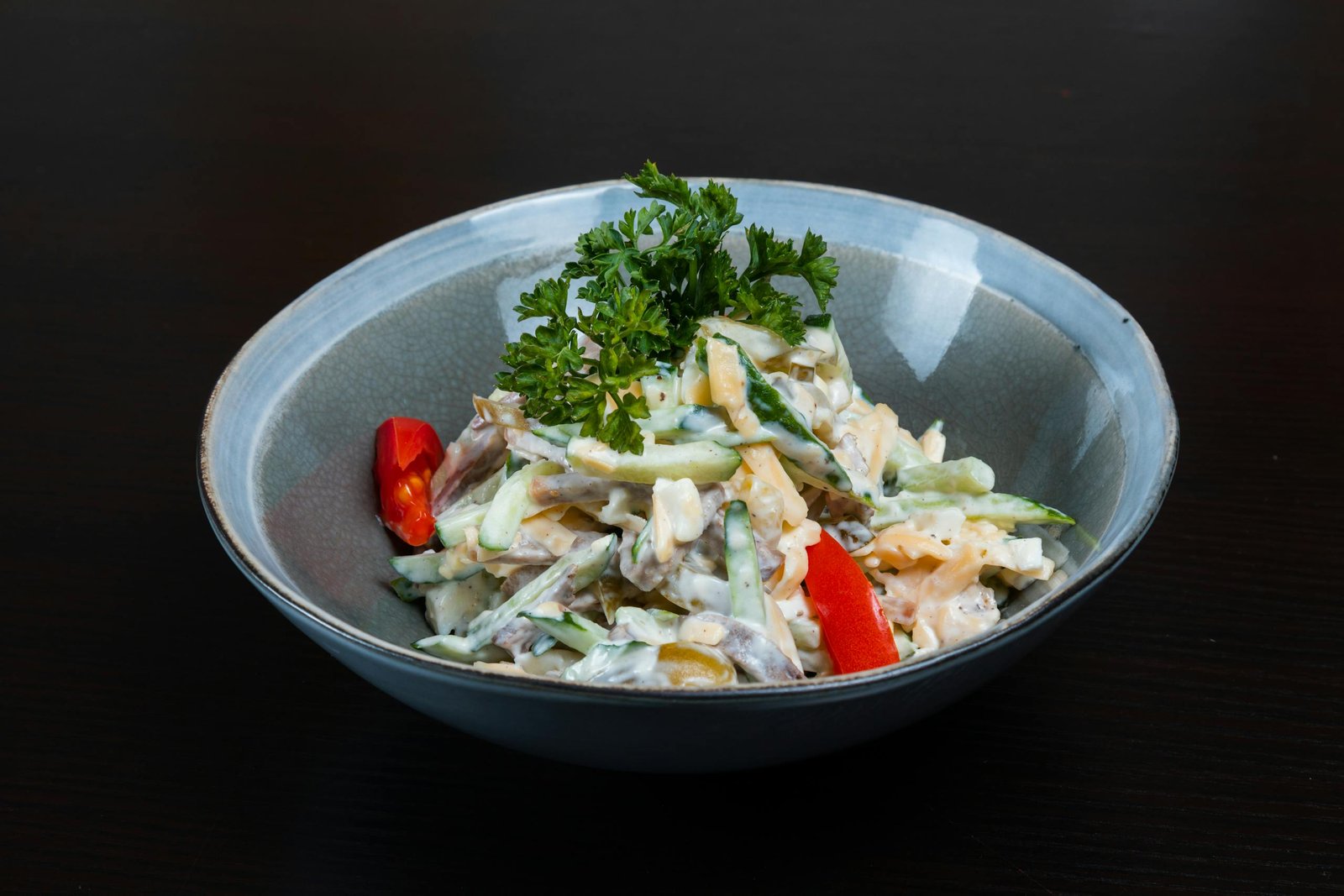 A fresh and colorful vegetable salad in a bowl with creamy dressing, perfect for healthy eating.