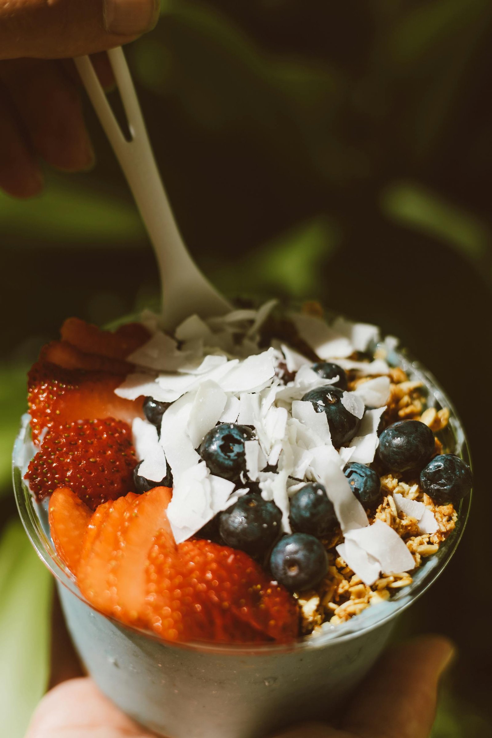 Delicious acai bowl topped with fresh strawberries, blueberries, and coconut flakes, perfect for a healthy snack.